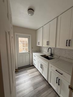 unfurnished living room featuring ceiling fan, crown molding, and wood finished floors