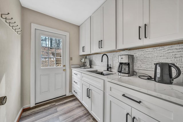 4937 Greenlee Rd SW, Roanoke, VA 24018 - kitchen with a sink, backsplash, light stone countertops, light wood-style floors, and white cabinets