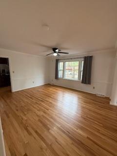 unfurnished living room with wood finished floors and a fireplace with raised hearth