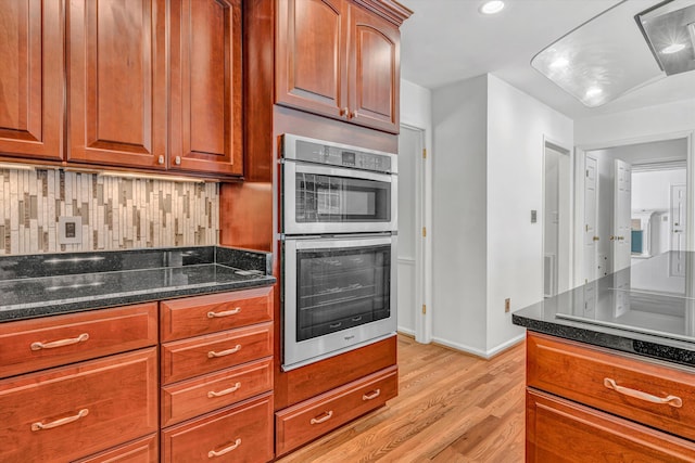 4937 Greenlee Rd SW, Roanoke, VA 24018 - kitchen with double oven, light wood finished floors, dark stone countertops, recessed lighting, and brown cabinets