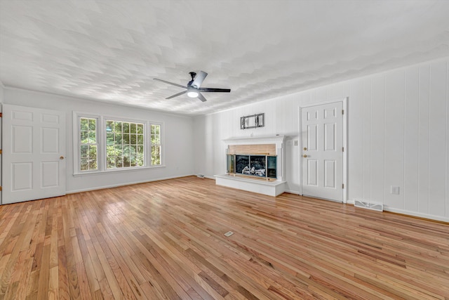 4937 Greenlee Rd SW, Roanoke, VA 24018 - unfurnished living room with light wood-style flooring, a ceiling fan, and a fireplace with raised hearth