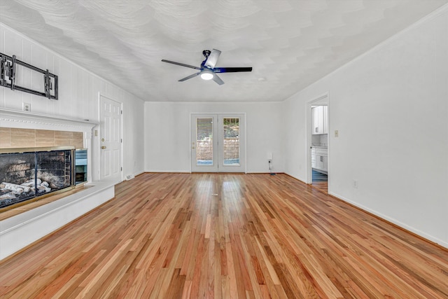 4937 Greenlee Rd SW, Roanoke, VA 24018 - unfurnished living room with ceiling fan, light wood-style floors, a tiled fireplace, and french doors