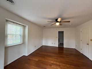 empty room featuring baseboards, visible vents, wood finished floors, and ceiling fan
