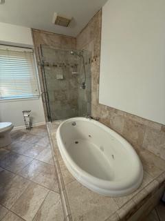 bathroom with a whirlpool tub, a shower stall, visible vents, and vanity