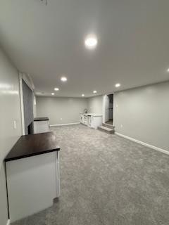 finished below grade area with baseboards, recessed lighting, and carpet flooring