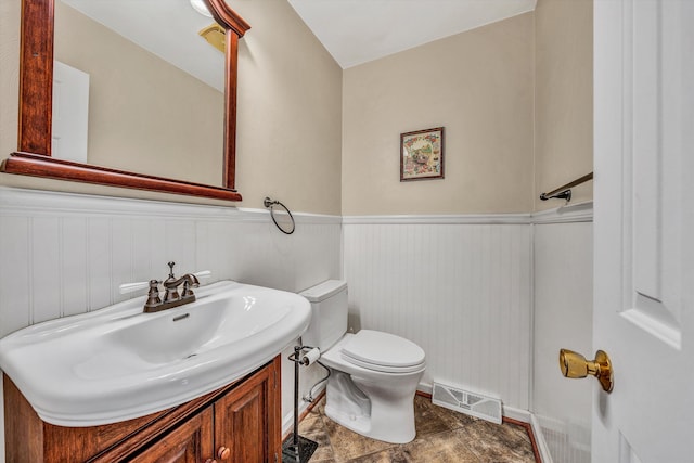 bathroom featuring visible vents, a wainscoted wall, toilet, and vanity