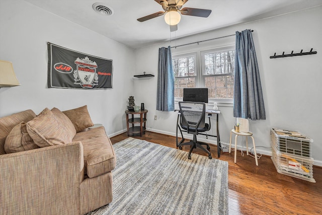office area featuring wood finished floors, visible vents, a ceiling fan, and baseboards