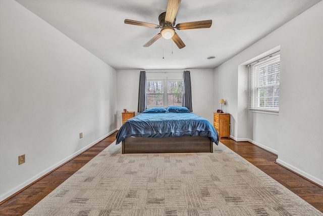 bedroom featuring wood finished floors, baseboards, and multiple windows