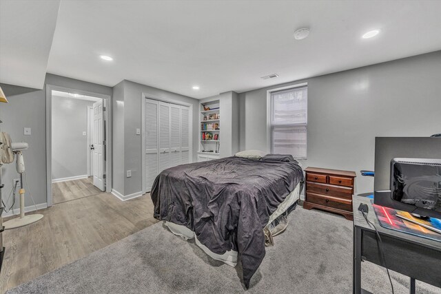 bedroom featuring recessed lighting, a closet, visible vents, baseboards, and wood finished floors