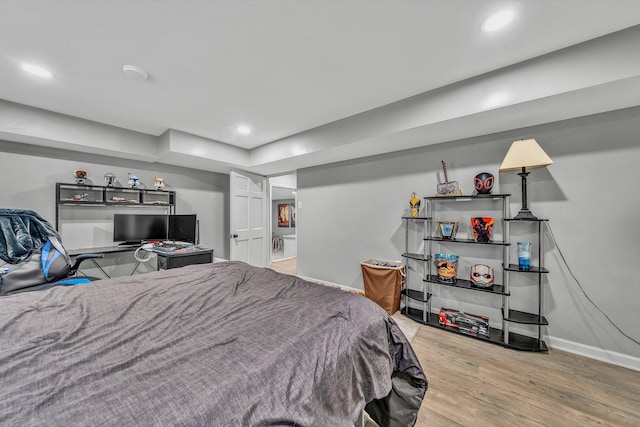 bedroom with recessed lighting, wood finished floors, and baseboards