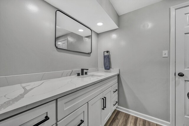 bathroom featuring vanity, wood finished floors, and baseboards