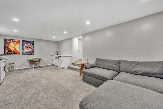 living room with recessed lighting, wet bar, light carpet, and baseboards