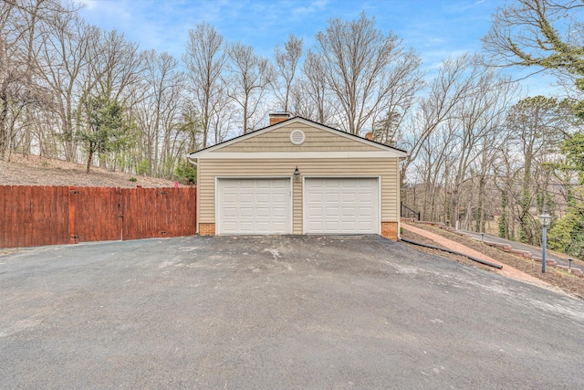 detached garage featuring fence