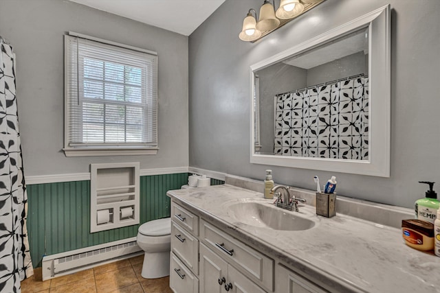 bathroom with tile patterned flooring, toilet, a wainscoted wall, vanity, and baseboard heating