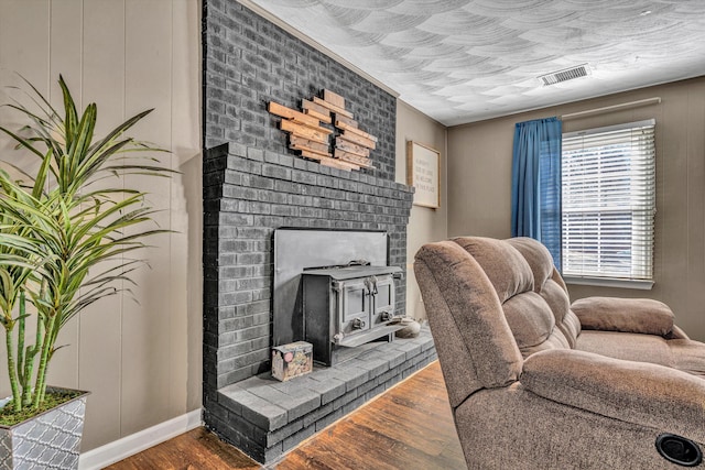 living area featuring a textured ceiling, wood finished floors, and visible vents