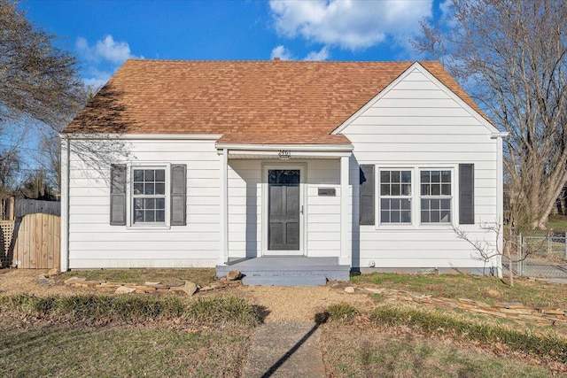 view of front of house with a shingled roof and fence