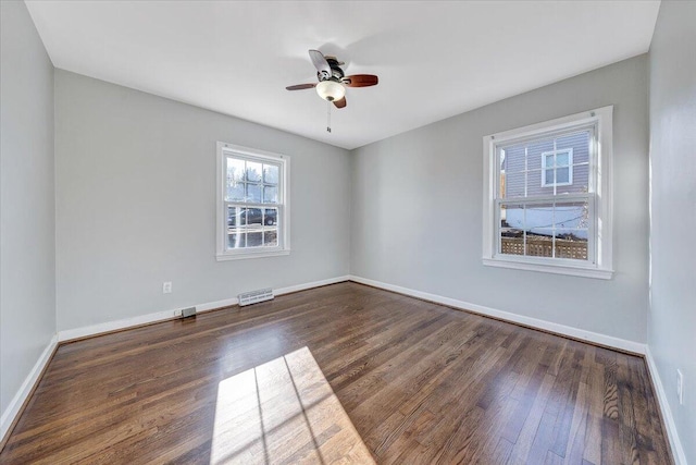 spare room with dark wood-style floors, ceiling fan, and baseboards