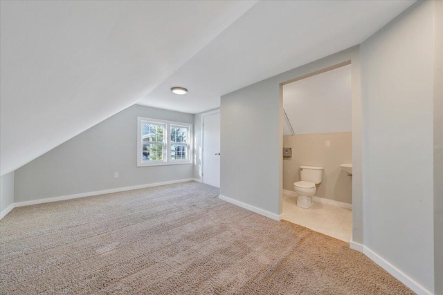 bonus room with lofted ceiling, light carpet, and baseboards