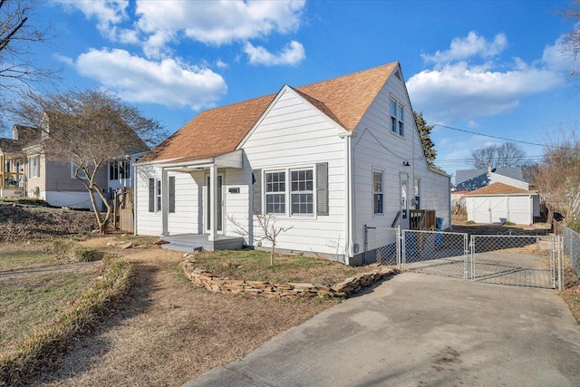 bungalow-style home featuring concrete driveway, fence, and a gate