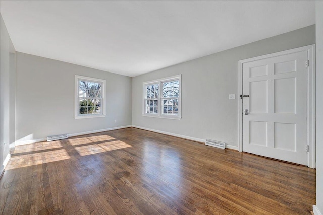 interior space featuring dark wood-style floors, visible vents, and baseboards