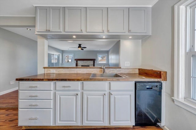 kitchen featuring black dishwasher, ceiling fan, a sink, and white cabinetry