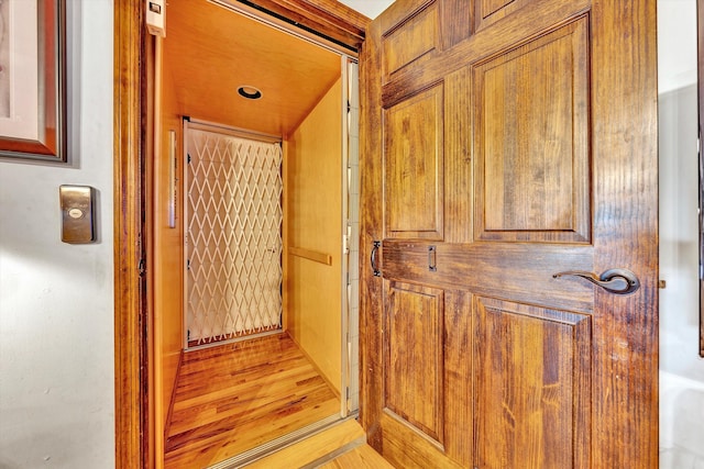 hall with elevator and light wood finished floors