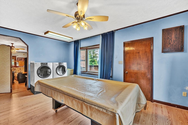 recreation room featuring a textured ceiling, light wood-style floors, and washer and dryer