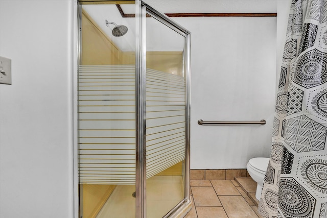 full bath with a stall shower, toilet, and tile patterned floors