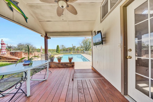 wooden deck featuring an outdoor pool and ceiling fan