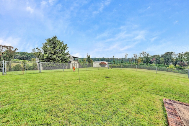 view of yard with an outbuilding, a storage unit, and fence