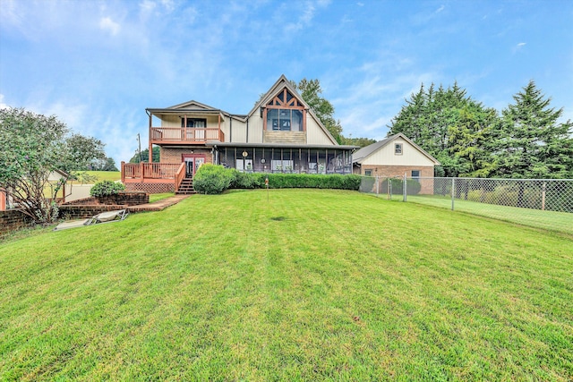 rear view of property featuring a sunroom, a fenced backyard, a deck, and a yard