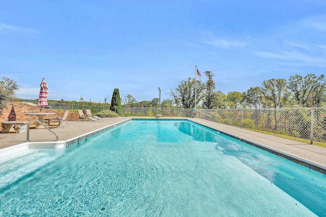 view of swimming pool featuring a patio, fence, and a fenced in pool