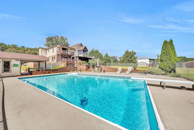 outdoor pool with a patio area and fence