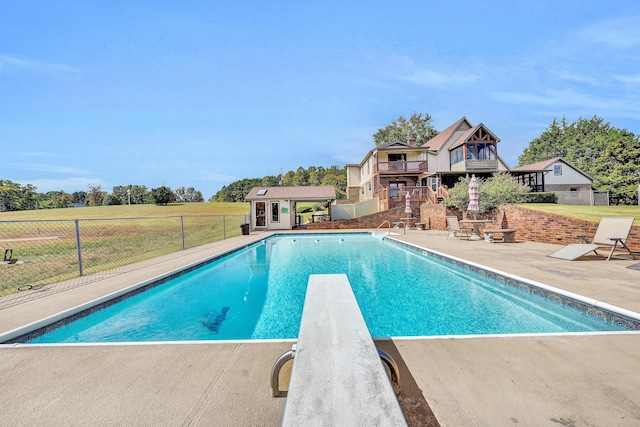 view of swimming pool with a fenced in pool, a patio, fence, an outdoor structure, and a storage structure