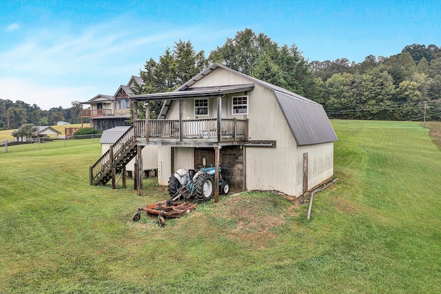 back of property featuring fence, a lawn, a deck, and stairs