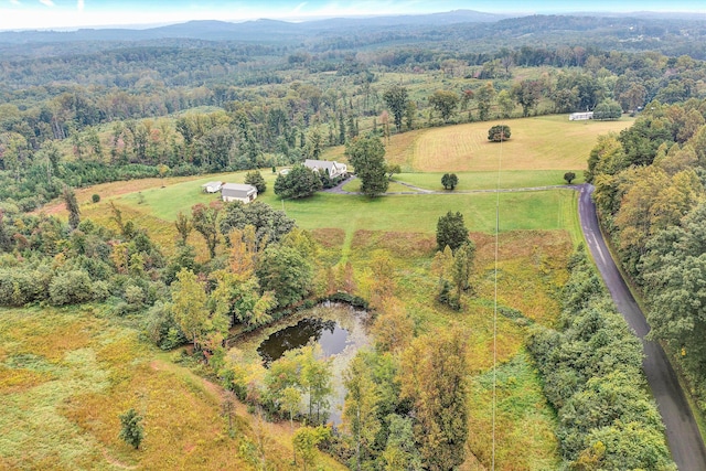 aerial view featuring a water and mountain view and a view of trees