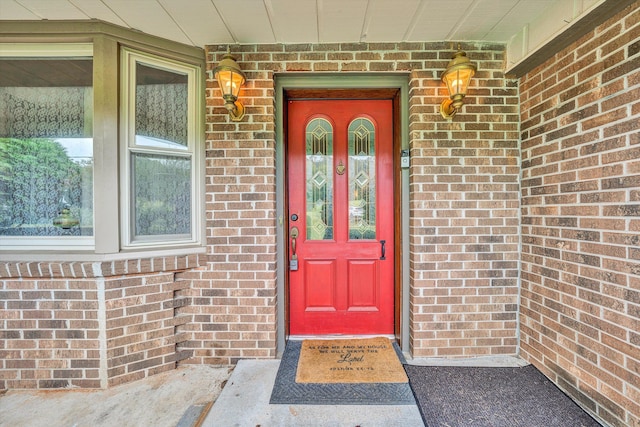 view of exterior entry featuring brick siding