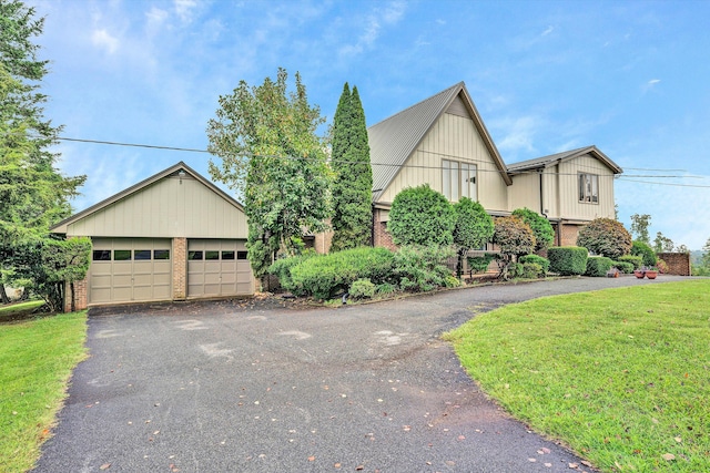 view of front of property featuring brick siding, a front lawn, and a detached garage