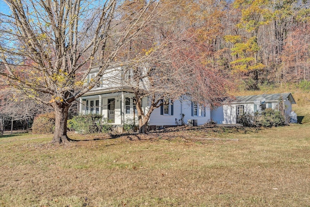 view of front facade with covered porch, a front lawn, and cooling unit