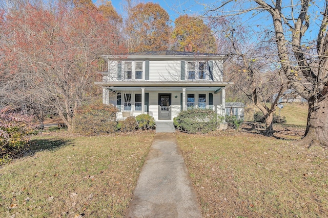 view of front of property with a porch, a chimney, and a front lawn