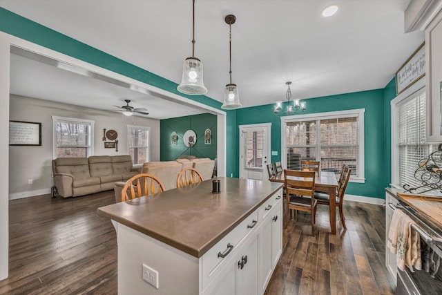 kitchen featuring hanging light fixtures, dark wood-style floors, white cabinetry, and a center island