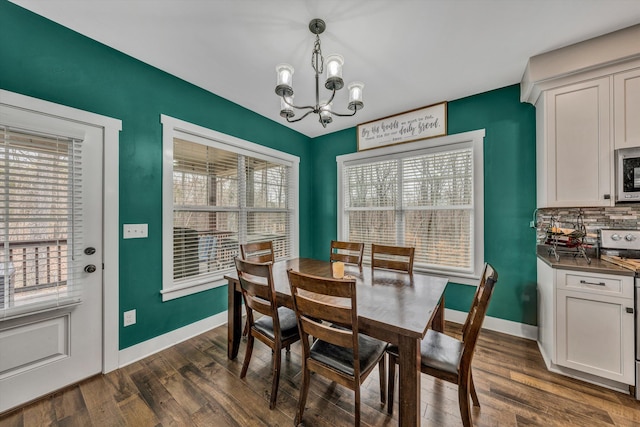 dining space featuring baseboards, a chandelier, and dark wood finished floors