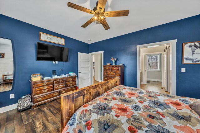 bedroom with ceiling fan, baseboards, and wood finished floors