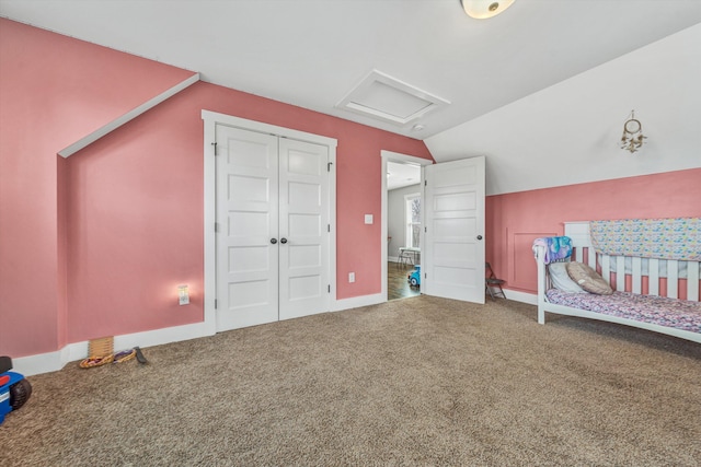 bedroom featuring carpet flooring, baseboards, vaulted ceiling, a closet, and attic access