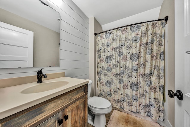 bathroom featuring wooden walls, curtained shower, vanity, and toilet