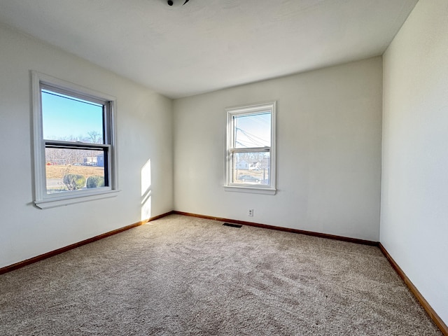 unfurnished room featuring carpet, baseboards, and visible vents