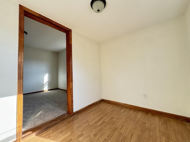 spare room featuring light wood-type flooring and baseboards