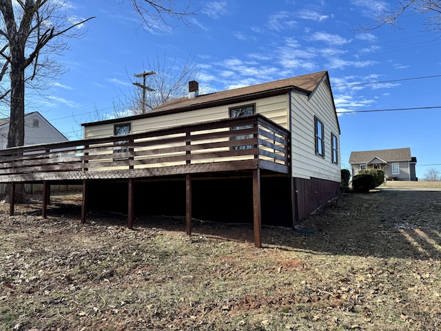 back of property featuring a deck and a chimney