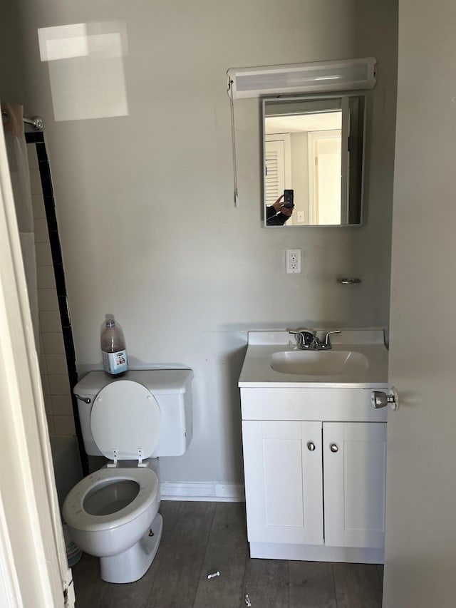 full bathroom with a bathtub, vanity, toilet, and baseboards