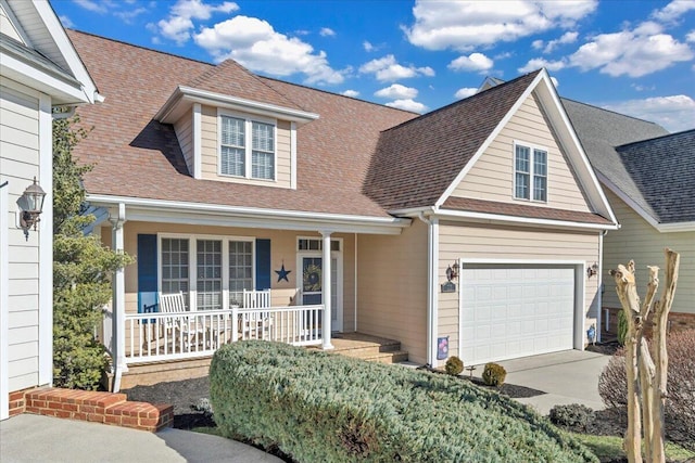 view of front of property with a porch, concrete driveway, a shingled roof, and a garage